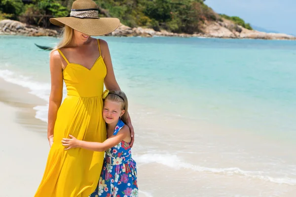 Nettes Mädchen und schöne Mutter am Strand Stockbild