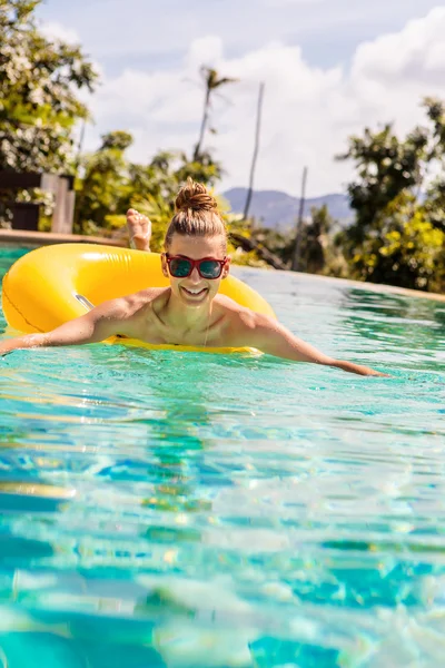 Sexig tjej med gul ring på pool party — Stockfoto