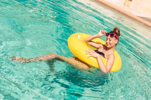 Sexig tjej med gul ring på pool party — Stockfoto