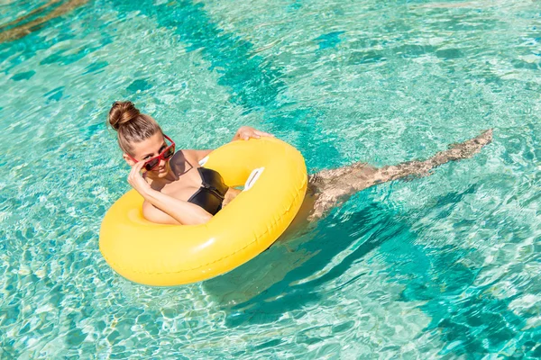 Sexig tjej med gul ring på pool party — Stockfoto