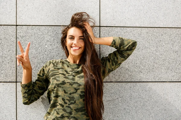 Happy girl in front of stone wall — Stock Photo, Image