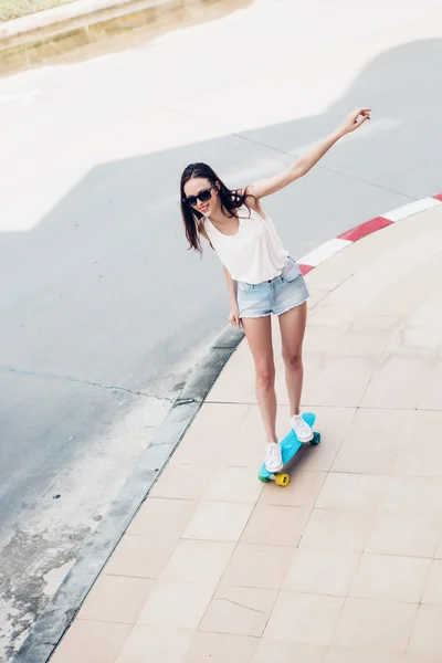 Hipster-Mädchen mit Skateboard auf der Straße. — Stockfoto