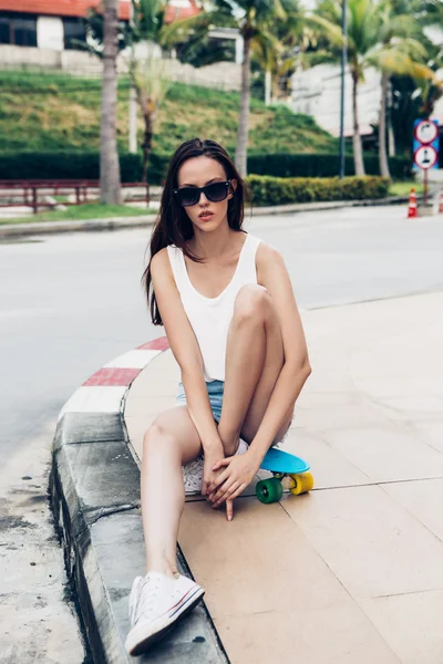 Hipster chica con monopatín en la calle . — Foto de Stock