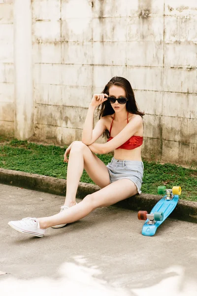 Мила дівчина хіпстера в бікіні зі скейтбордом . — стокове фото