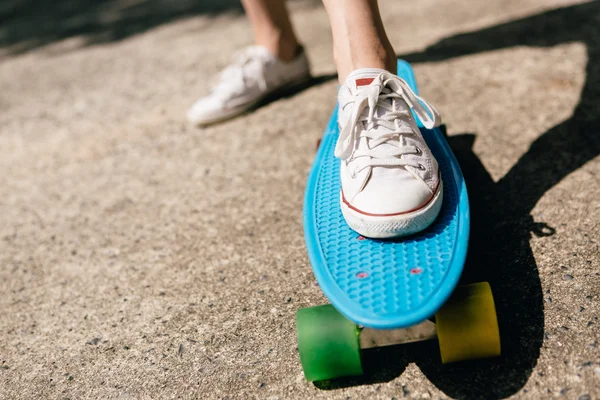 Giovane ragazza in sneakers su skateboard . — Foto Stock