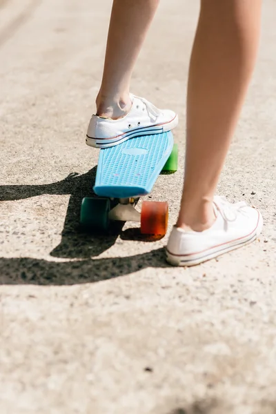 Young girl in sneakers on skateboard. — Stock Photo, Image