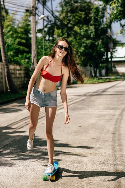Söta hipster tjej i bikini med skateboard. — Stockfoto