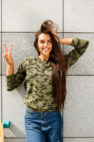 Fille heureuse devant le mur de pierre Photo De Stock