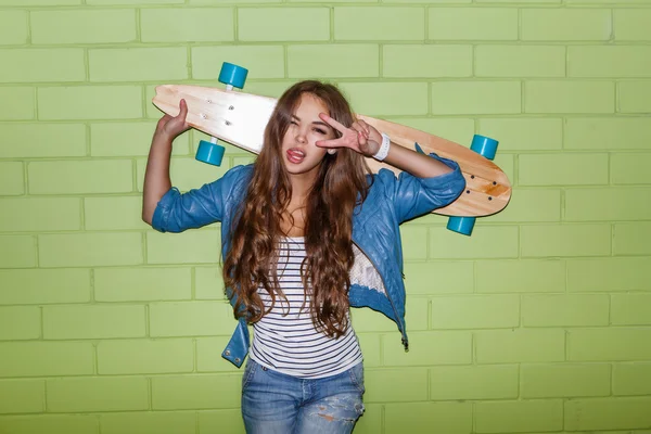 Woman with longboard show victory sign — 图库照片