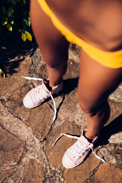 Ganska atletisk flicka i gul bikini sexig sticka på footpat — Stockfoto