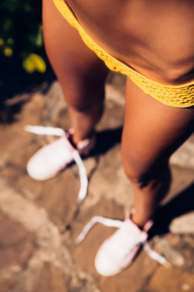 Красива спортивна дівчина в жовтому бікіні сексуальне в'язання на нозі — стокове фото