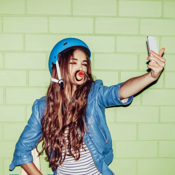 Girl in blue helmet taking a selfie — Stockfoto