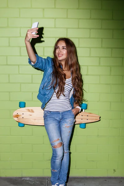 Hipster schöne Mädchen mit Skateboard — Stockfoto