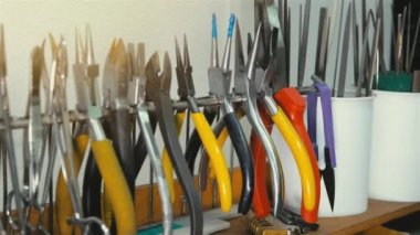 Mücevher atölyesi, duvarda aletler asılı, ustanın eli ufaklıkları işe götürüyor.