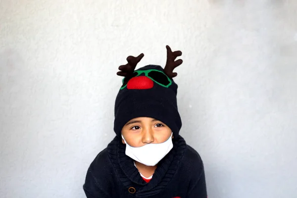 拉丁裔男孩7岁 头戴圣诞帽 头戴驯鹿耳朵 头戴毛衣 圣诞装饰 — 图库照片