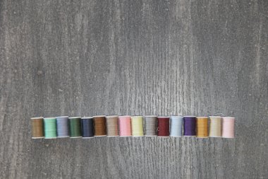 Vintage ahşap arka planda dikim ve moda tasarımı için renkli iplik makaraları seti