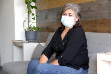 Yaşlı kadın, koruyucu maskeli büyükanne bekleme odasında covid-19 için klinik kullanım, küresel salgın nedeniyle yeni normal