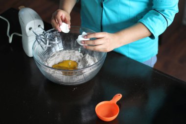 Latin kadın şef mutfak gereçleriyle pasta için un hazırlıyor.