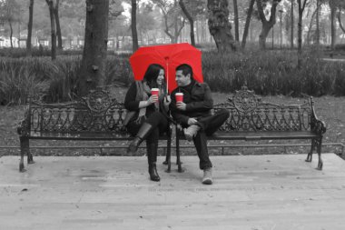 Sevgililer Günü 'nde şehirde kırmızı şemsiyeli siyah beyaz bir çift.