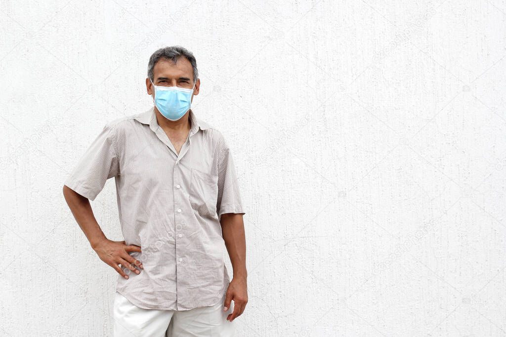 Latino elderly with protective face masks on white wall background, new normal covid-19