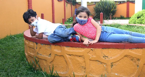 Letni Chłopiec Dziewczynka Maskach Ochronnych Dla Wirusa Covid Siedzący Parku — Zdjęcie stockowe
