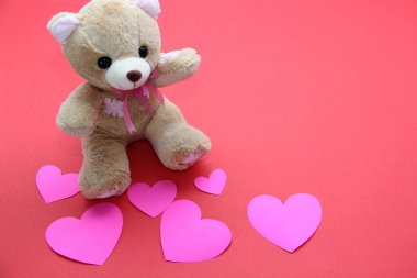 Oyuncak ayı, bir kutu çikolata ve kırmızı arka planda kurdeleli pembe kalpler Sevgililer Günü hediyeleri, reklam afişi.