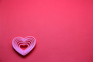 Kırmızı arka planda kurdeleli pembe kalpler, Sevgililer Günü, reklam afişi