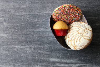 Eski gri masa üzerinde Meksika usulü tatlı ekmek. Kabuk, kek, papyon, kulak, çok renkli dallı bisküvi.