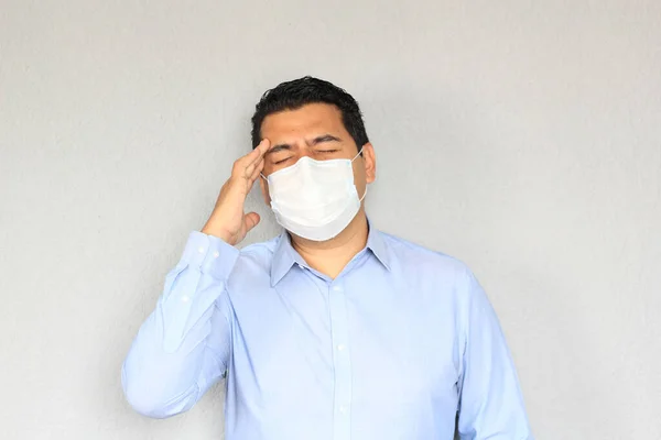 Formal adult latin man with protection mask, sneezing and covid-19 symptoms