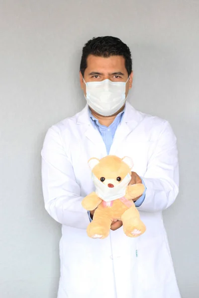 拉丁儿科医生 头戴白色外套 戴保护膜 头戴泰迪熊 预防眼镜蛇 新常态 — 图库照片