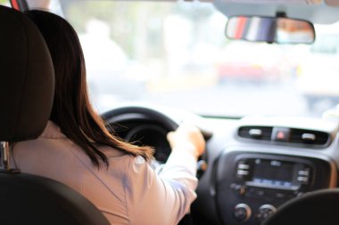 Latin kadın sürücü araba içinde koruma maskesi takıyor. Klinik kullanım: covid