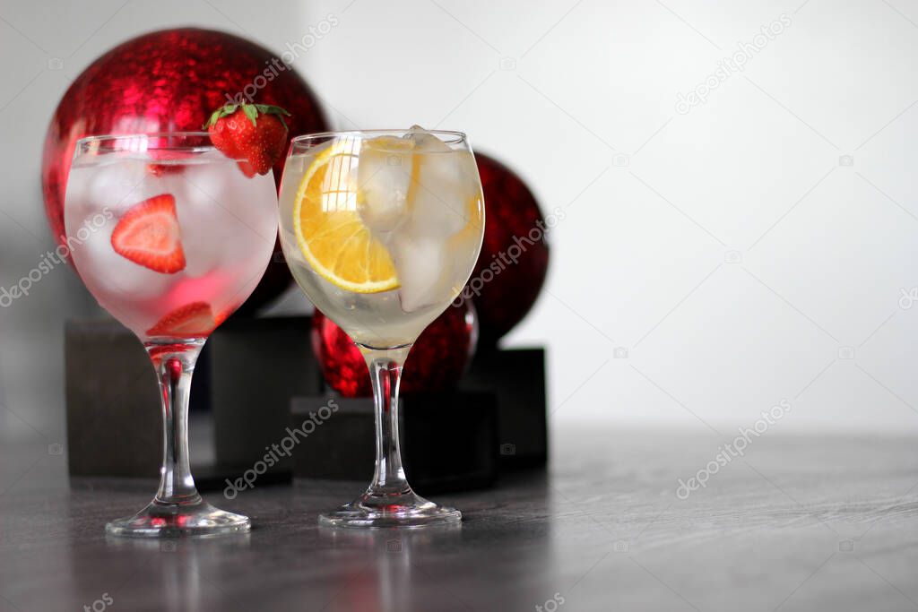 strawberry and orange gin on vintage gray table with red spheres