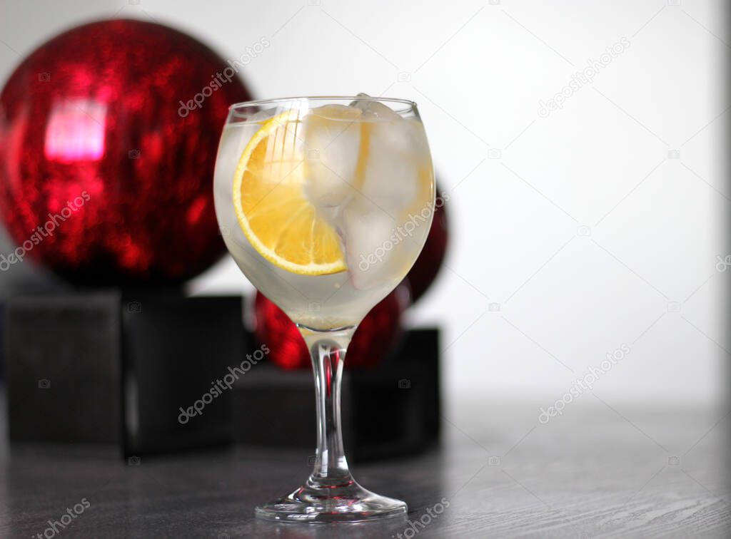 orange gin on vintage gray table with red spheres