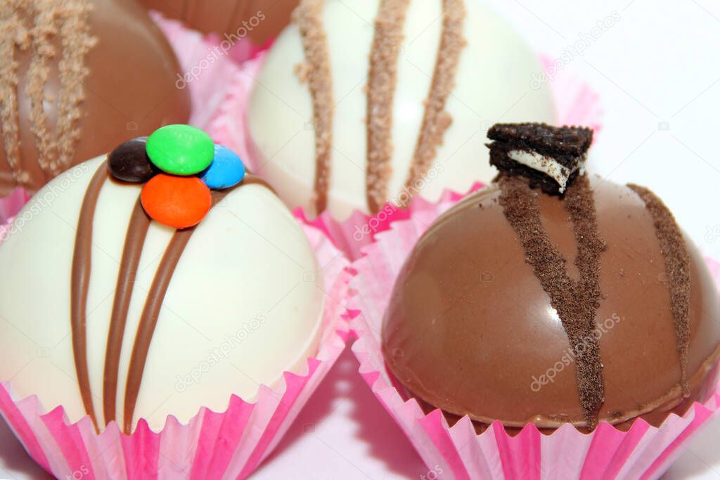 Set of chocolate bombs, marshmallow filling and white chocolate on white background