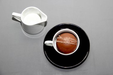 Çikolata bombaları bardakta sıcak süt, marşmelov ve beyaz arka planda beyaz çikolata.