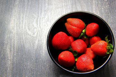 Siyah tabakta kırmızı çilek. Klasik gri ahşap arkaplan