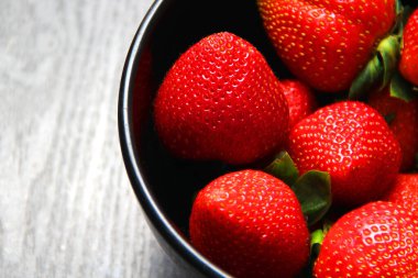 Siyah tabakta kırmızı çilek. Klasik gri ahşap arkaplan