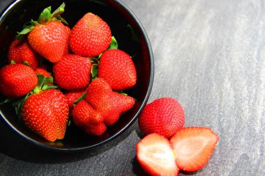 Siyah tabakta kırmızı çilek. Klasik gri ahşap arkaplan