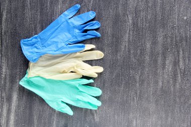 Covid-19 koruma ekipmanları. Lastik eldivenler, gözlükler, maskeler ve gri arka planda antibakteriyel jel.