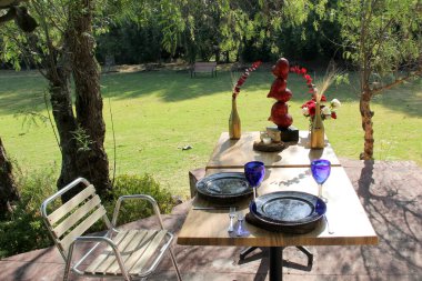 Sevgililer Günü 'nde çiçeklerin ve kalplerin süslendiği açık havada romantik yemek sofrası.