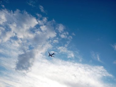 Bulutların arasında mavi gökyüzünde uçan uçak