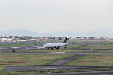 Bulutlar ve dağlar arasında mavi gökyüzü olan uçak kalkıyor ya da iniyor