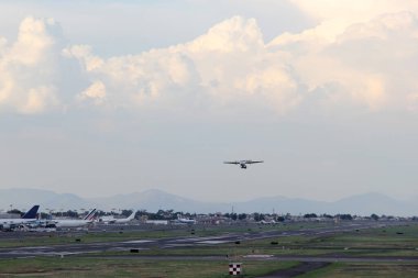 Bulutlar ve dağlar arasında mavi gökyüzü olan uçak kalkıyor ya da iniyor