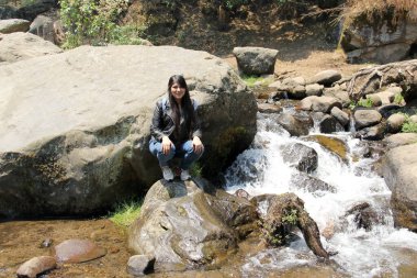 Ormanın ortasında yalnız bir kadın nehirler ve şelaleler arasında meditasyon yapıyor.