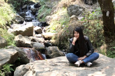 Ormanın ortasında yalnız bir kadın nehirler ve şelaleler arasında meditasyon yapıyor.