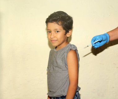 Sağlıklı 7 yaşındaki fakir yerli Latin çocuk gribe ve covid 19 'a karşı aşı oluyor.