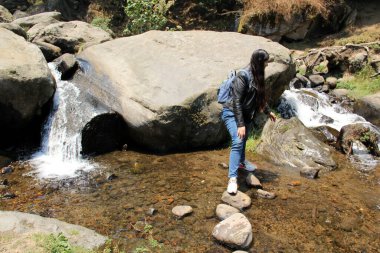 Genç Latin kadın ormanı keşfediyor. Doğanın ortasında nehirler ve şelaleler arasında.