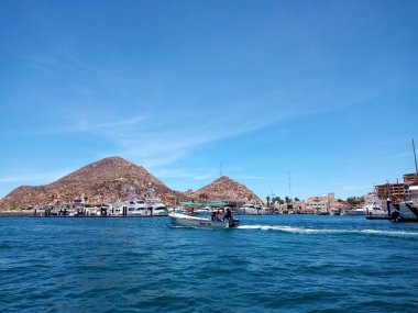 Los Cabos 'un kayalık dağlarıyla çevrili derin mavi Cortez Denizi' ndeki tekne limandan ayrılıyor.