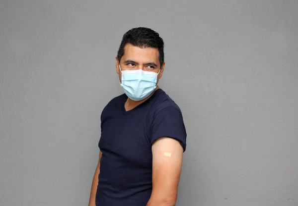 Здоровый Латиноамериканец Маске Показывающий Руку Недавно Получившую Вакцину Ковид — стоковое фото