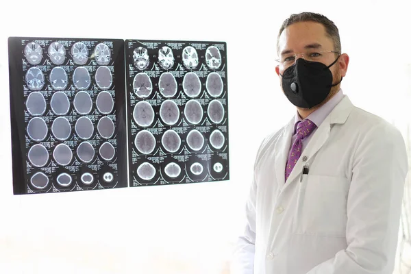 神经科专科医生 戴着口罩 身穿长袍 对脑部X光或Ct扫描进行检查 是他的专业工作 — 图库照片